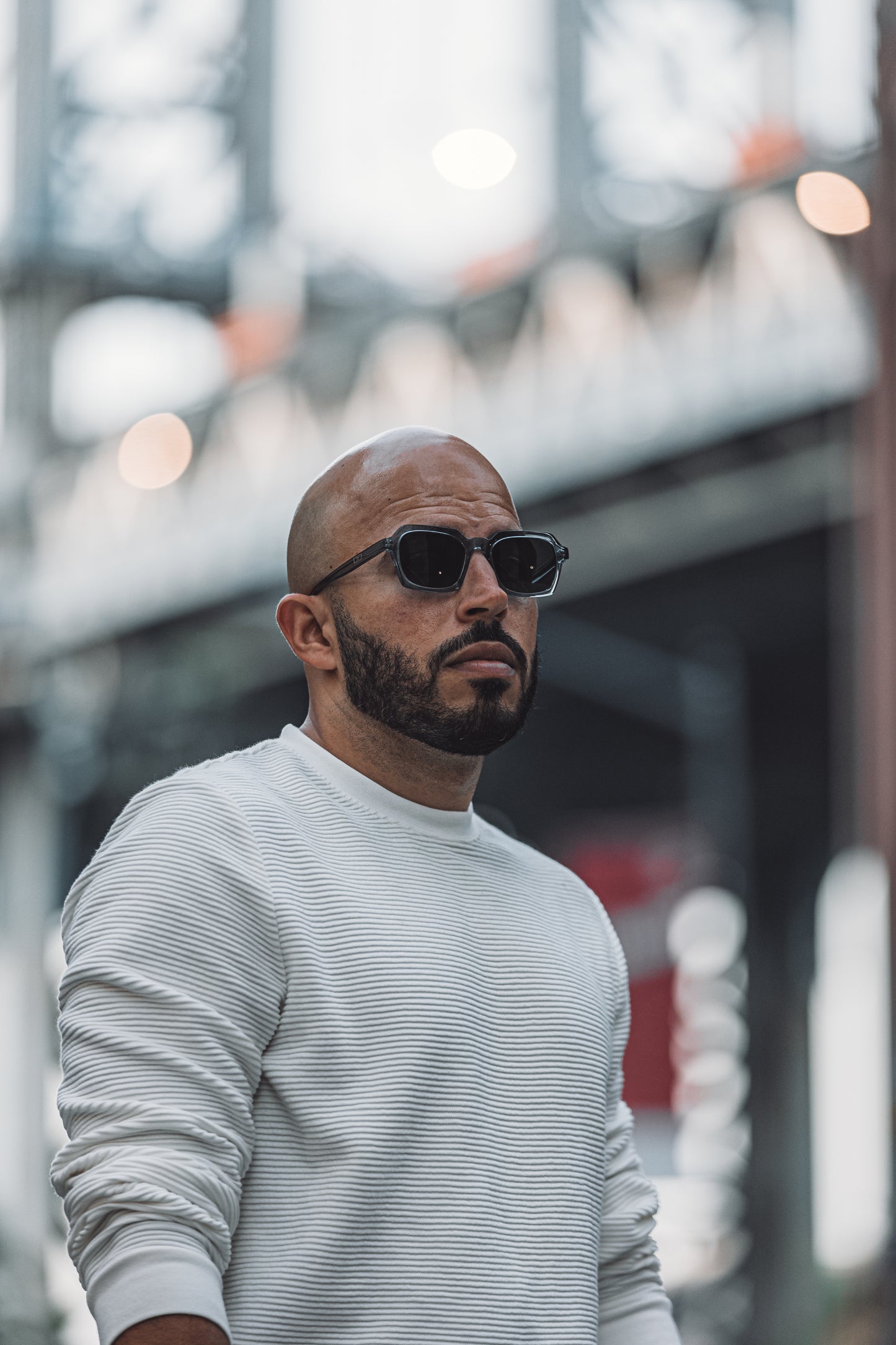 Hombre usando gafas de sol grises transparentes marca CHE modelo Mirna estilo urbano Puerto Rico