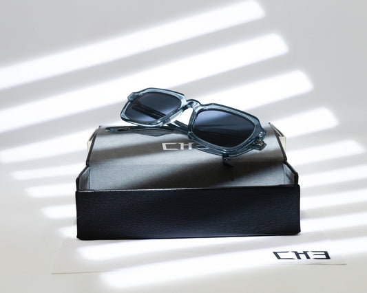 Gafas de sol acetato japonés Smoke Gray transparentes sobre mesa con sombras