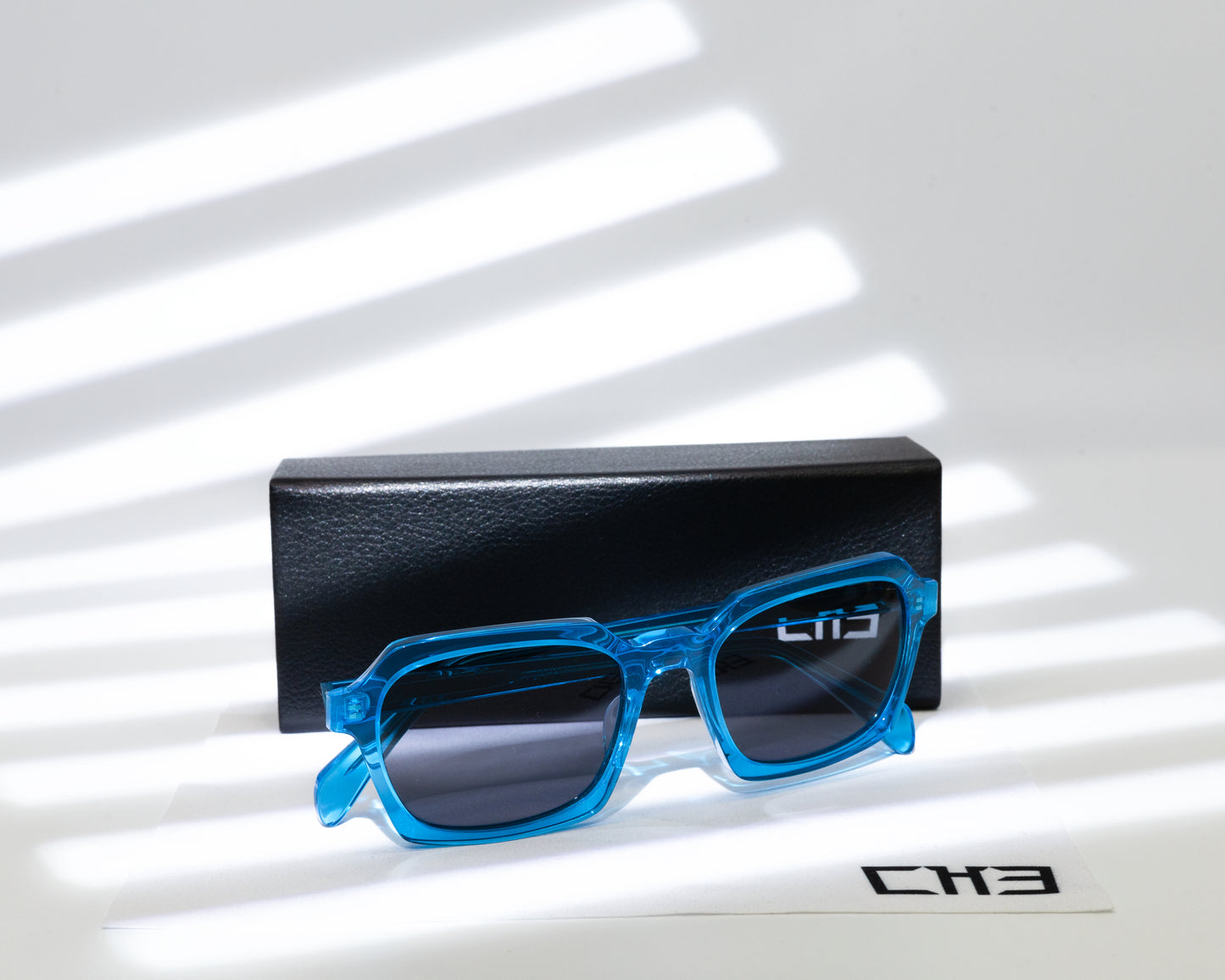 Espejuelo Gafas de sol acetato japonés azules transparente sobre mesa con sombras