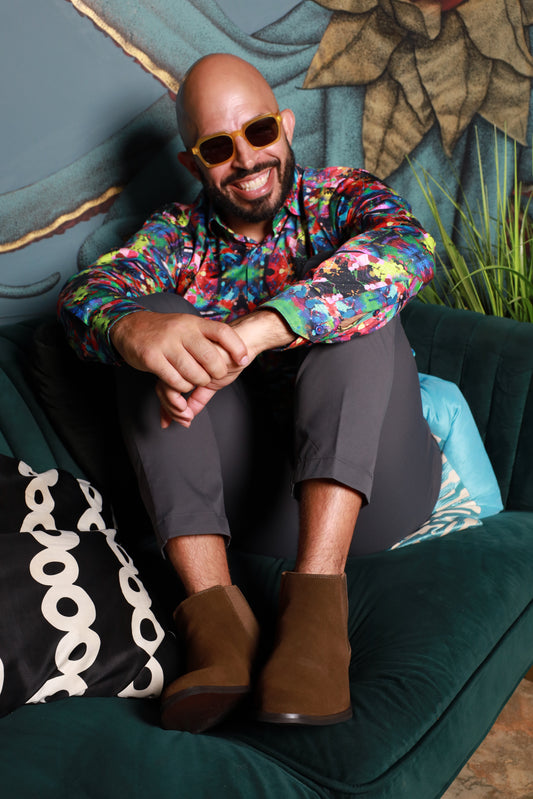 Hombre sonriente usando gafas de sol amarillas transparentes marca CHE modelo Mirna Icon estilo urbano Puerto Rico.